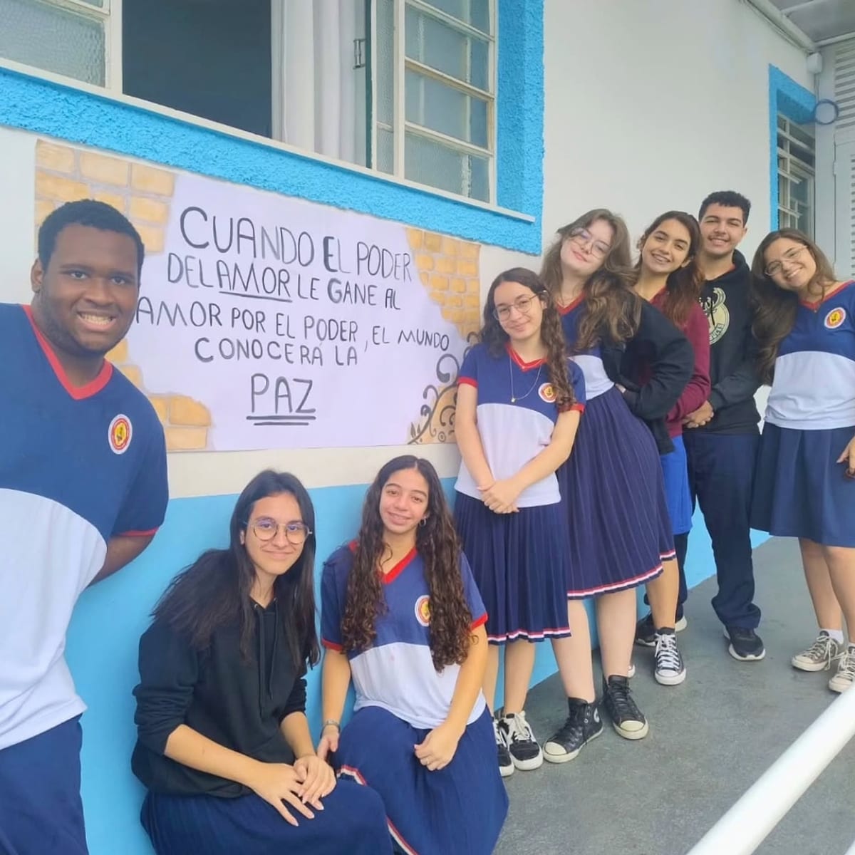 Alunos da 2ª série do Ensino Médio ao lado de um cartaz com uma frase em espanhol